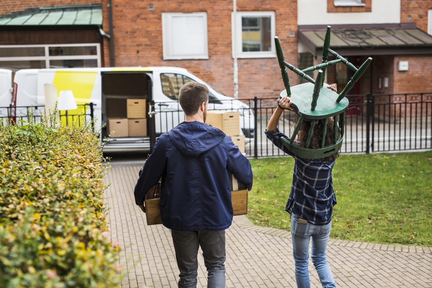 : "Personas cargando muebles y cajas hacia un vehículo para almacenar en Mini Bodegas