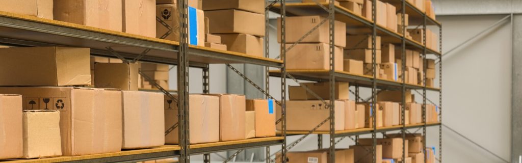 Estantes industriales llenos de cajas de cartón en una Mini Bodega, facilitando la eficiencia empresarial.