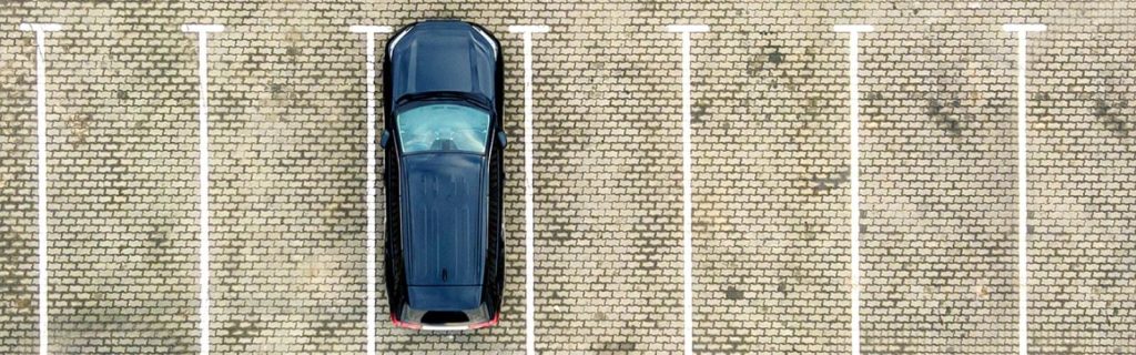 Vista aérea de un automóvil estacionado, ilustrando el servicio de almacenamiento de vehículos y flotillas.