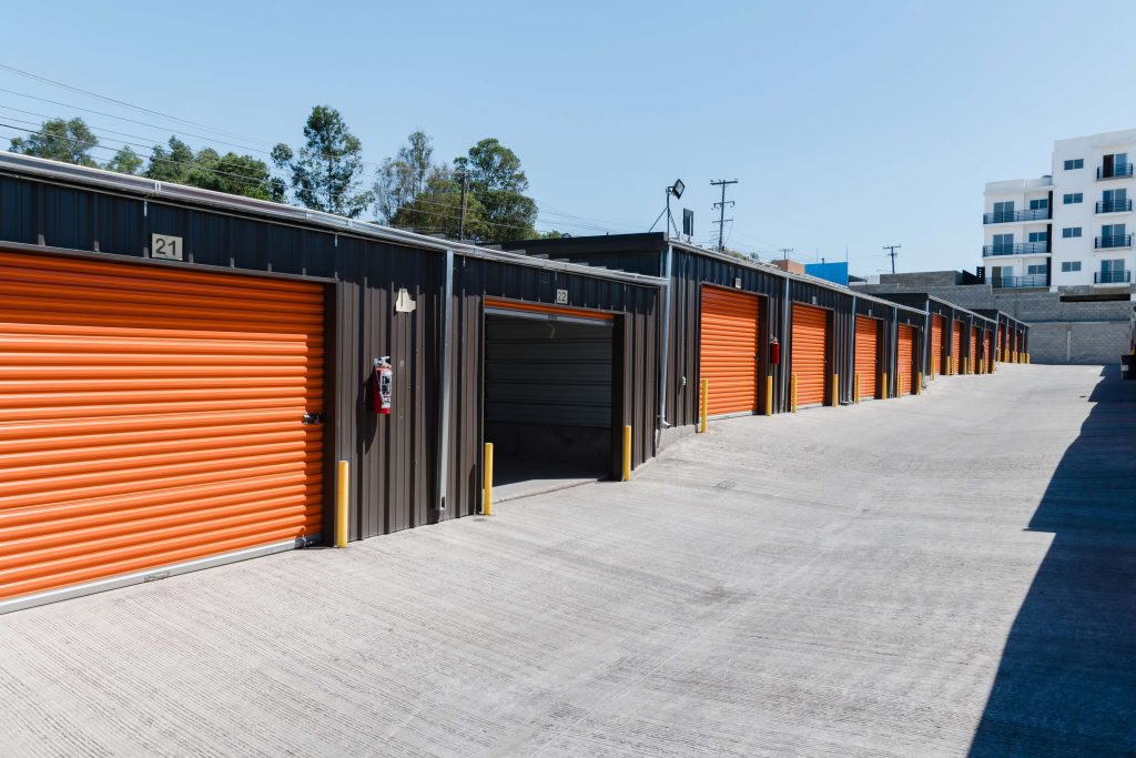 Larga fila de bodegas con puertas enrollables, representando soluciones de almacenamiento empresarial.